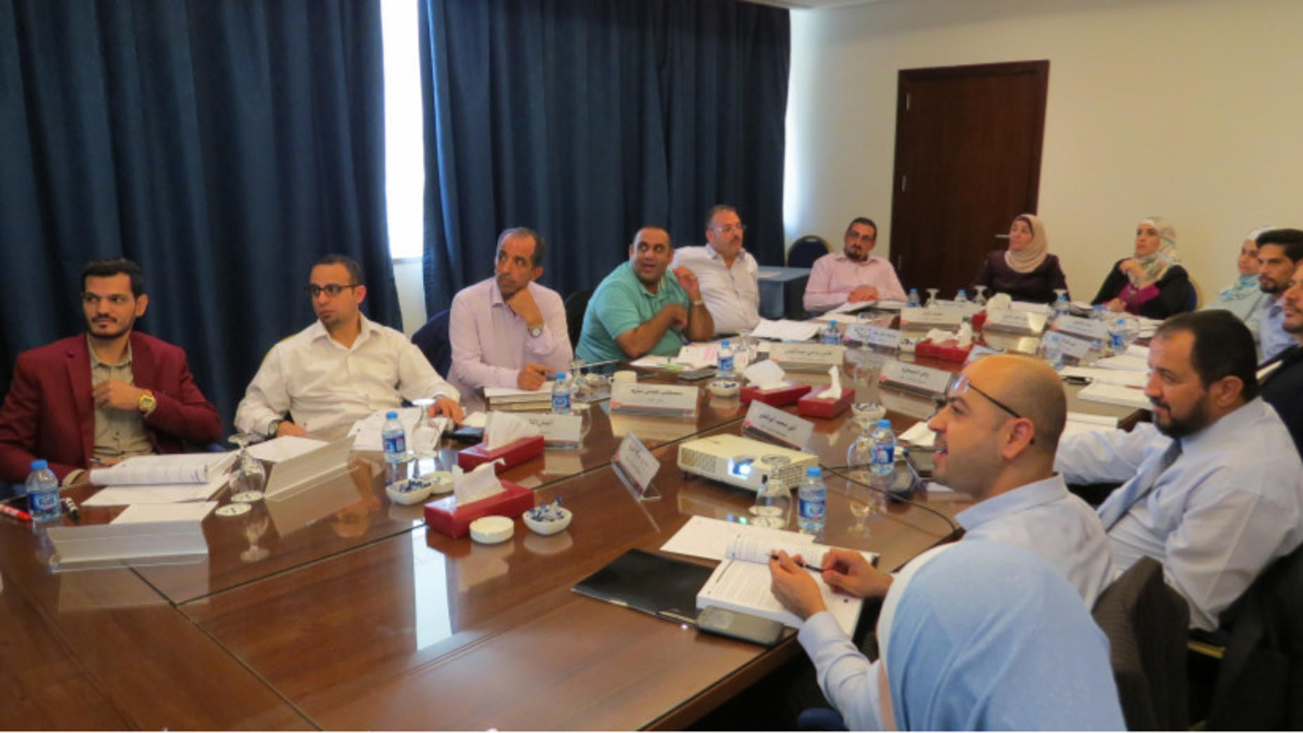 Professionals gathered around a boardroom table for controls training